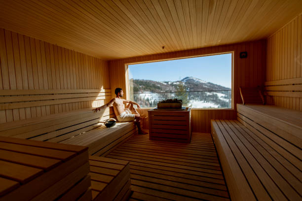 istock Young man relaxing in the sauna and watching winter forest through the window 1393978024
