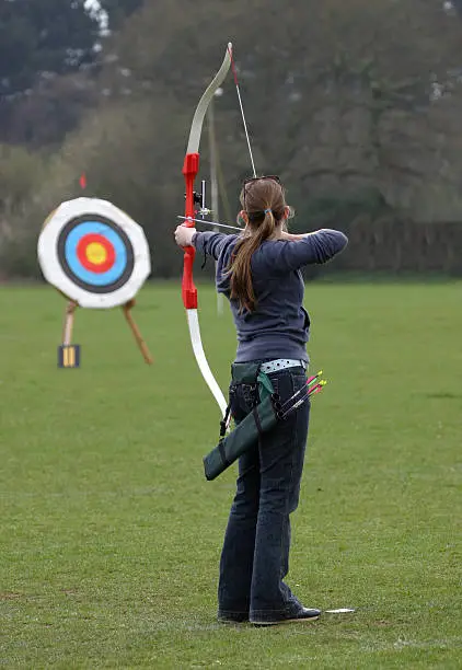Female archer aiming at target