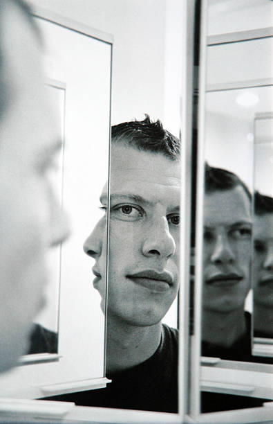 Infinite faces of a young man's reflection in a mirror