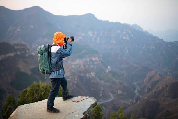 The photographer photographed the distant mountains at the top of the mountain stock photo