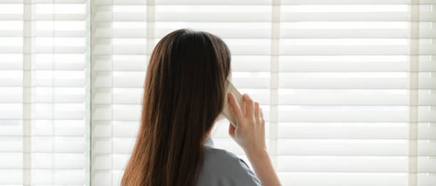 istock Asian woman looking out window 1393985476