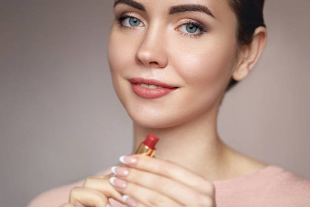 istock Close up  girl rouging her lips. red lipstick. 1393989651