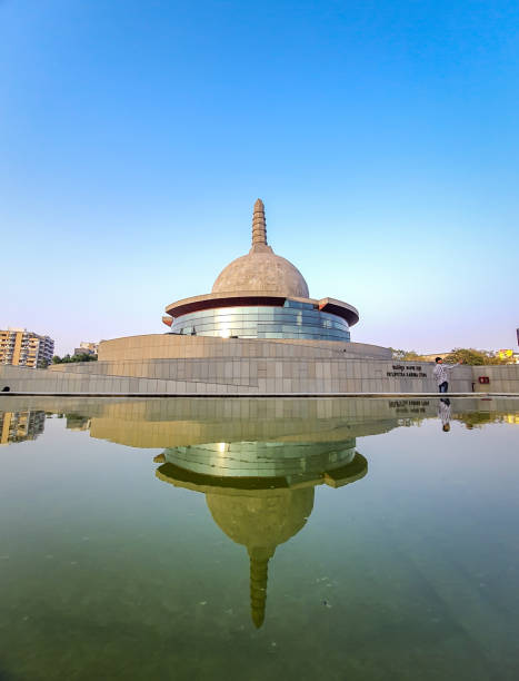 buddha stupa with water reflection and bright blue sky at morning