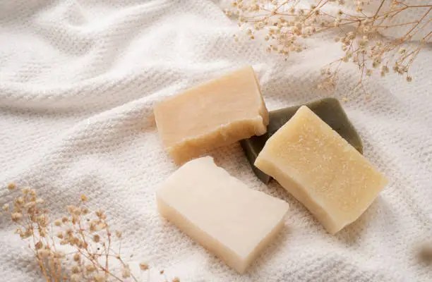 Photo of Handmade soap bars on white towel top view with copy space