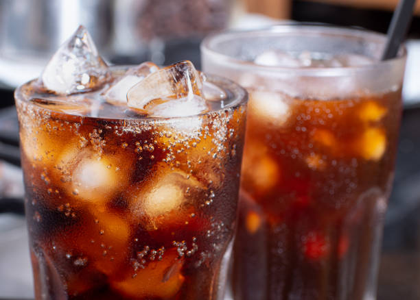 cola with crushed ice in glass and there is water droplets around. cool black fresh drink. - kola stok fotoğraflar ve resimler