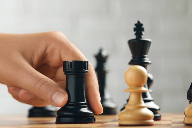 istock Woman moving chess piece on board, closeup 1393992058