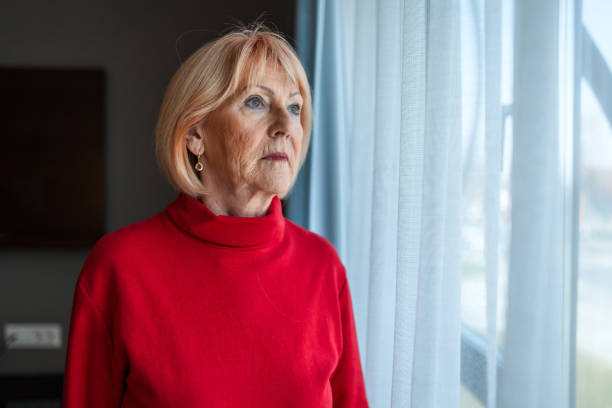 istock A Senior Woman Stares Out Through a Window 1393994480