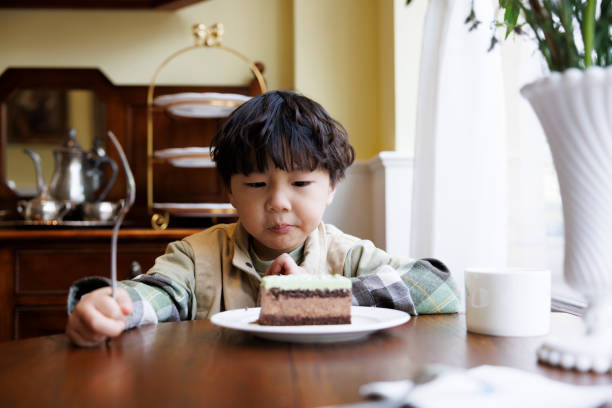 istock A little boy eating cake in the kitchen 1393994705