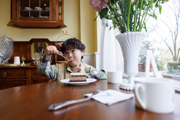 istock A little boy eating cake in the kitchen 1393994707