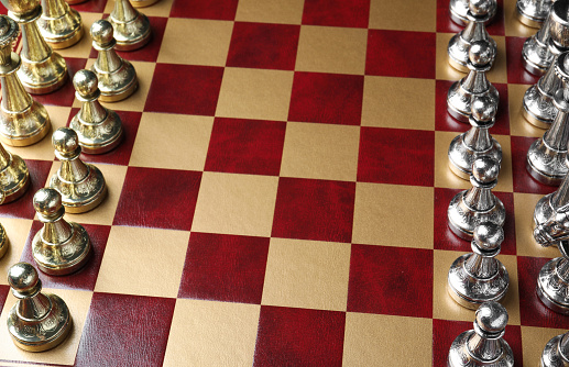 Wooden chessboard with game pieces, above view