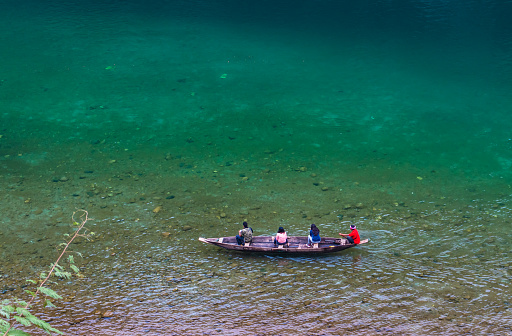 river clear water with traditional wood boat running at morning from different angle image is taken at umtong river dawki meghalaya india on Apr 03 2022.