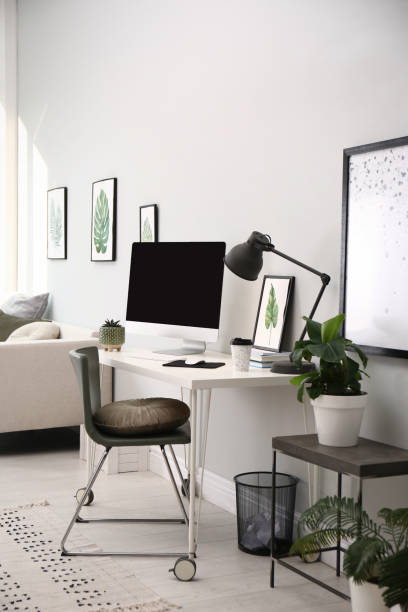 istock Comfortable workplace with modern computer and houseplants in room. Interior design 1394001757