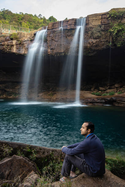 istock young man with waterfall streams falling from mountain top at morning long exposure shot 1394001773