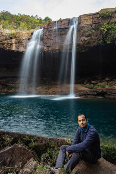 istock young man with waterfall streams falling from mountain top at morning long exposure shot 1394001829