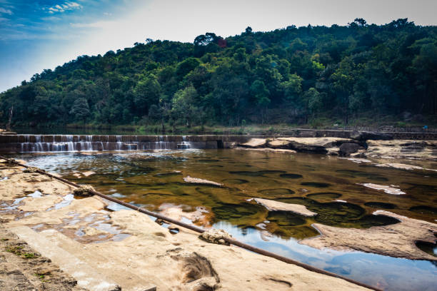 istock riverbed stone hole with water and surrounded by green forests from flat angle 1394002971