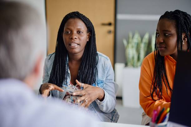 una donna incinta e un ostetrico maschio discutono delle possibili complicazioni durante il parto - homosexual homosexual couple black ethnic foto e immagini stock