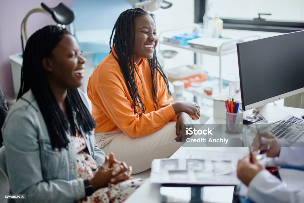 Happy pregnant woman visit gynecologist doctor at hospital or medical clinic for pregnancy consultant Same sex couple visiting  gynecologist office Human Fertility Stock Photo