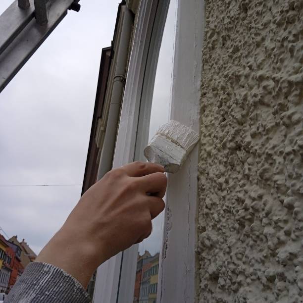 istock painter painting the window of a building 1394004012