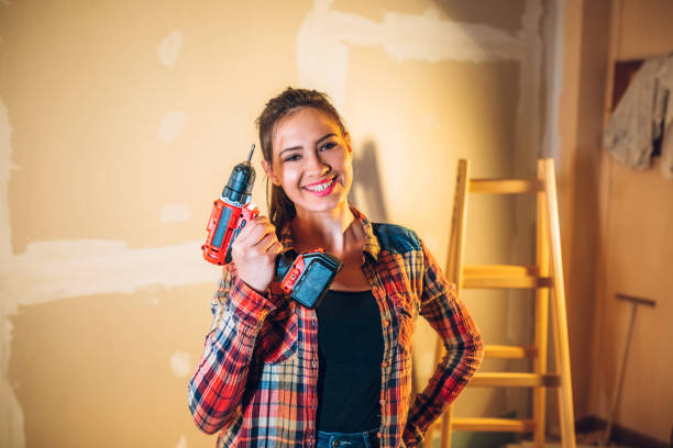 Young woman with drill Young beautiful caucasian woman renovating house with drill. holding drill stock pictures, royalty-free photos & images
