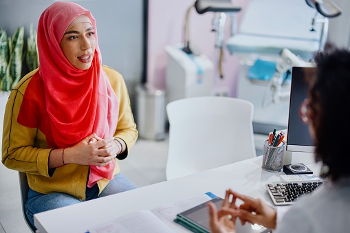 A Muslim patient reviews the results of medical tests with her female gynecologist