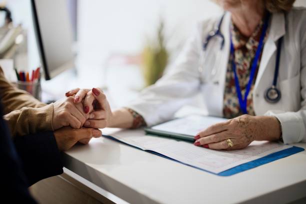 Shot of an unrecognizable doctor holding hands with her patients during a consultation Shot of an unrecognizable doctor holding hands with her patients during a consultation ovarian cancer stock pictures, royalty-free photos & images