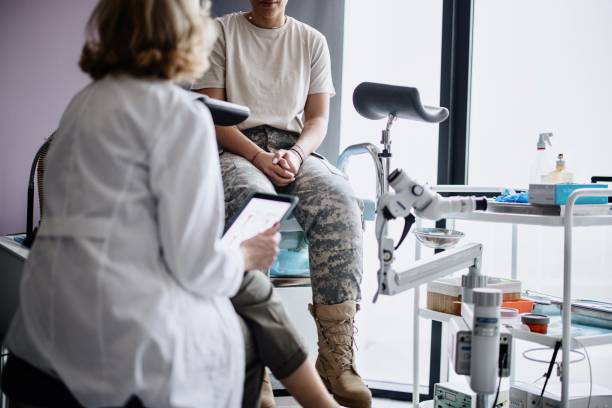 unkenntlicher soldat im gespräch mit ärztin - gynecological examination stock-fotos und bilder