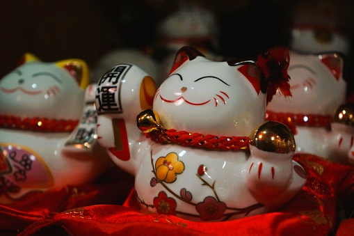 Asian lucky cats figurines on red cushions