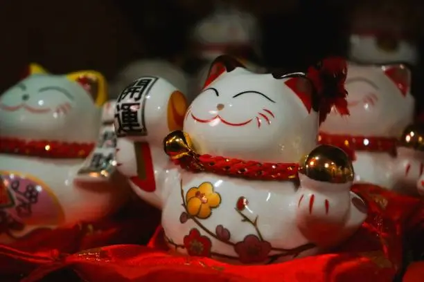 Asian lucky cats figurines on red cushions