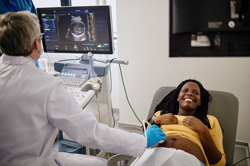 Pregnant Black woman having ultrasound exam during her monthly check up with her gynecologist