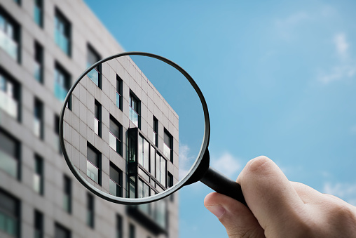 A magnifying glass focusing an apartment buidling facade with modern style