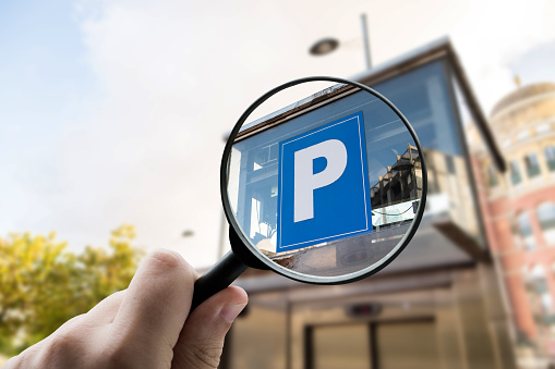 A magnifying glass focusing a parking lot sign