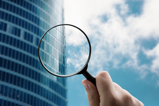 Magnifying glass focusing a modern office building