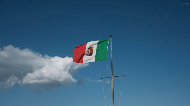 abril - itália 2022 - base militar em cagliari - sardenha - bandeira agitando a marinha italiana com céu azul e nuvens - naval flag - fotografias e filmes do acervo