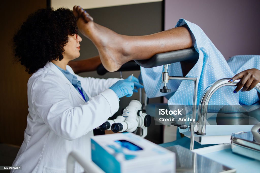 Female gynecologist doctor obtaining a cervical smear Pap Smear Stock Photo