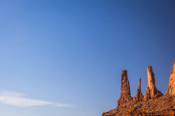 Classic southwest desert landscape under a blue sky and bright sun in Monument Valley in Arizona and Utah.