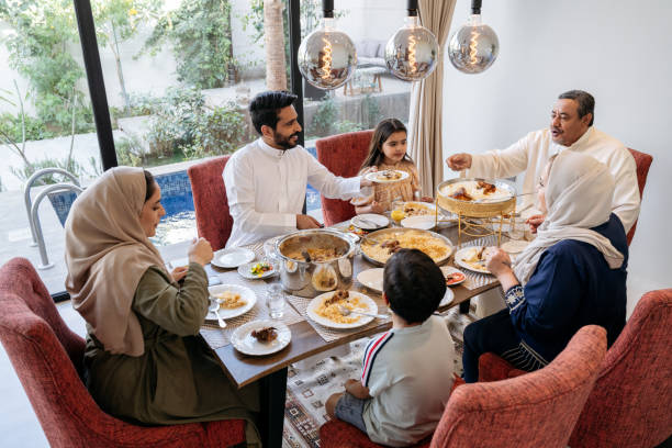 famiglia di riyadh di tre generazioni che mangia insieme il pasto di mezzogiorno - saudi arabia child ramadan offspring foto e immagini stock