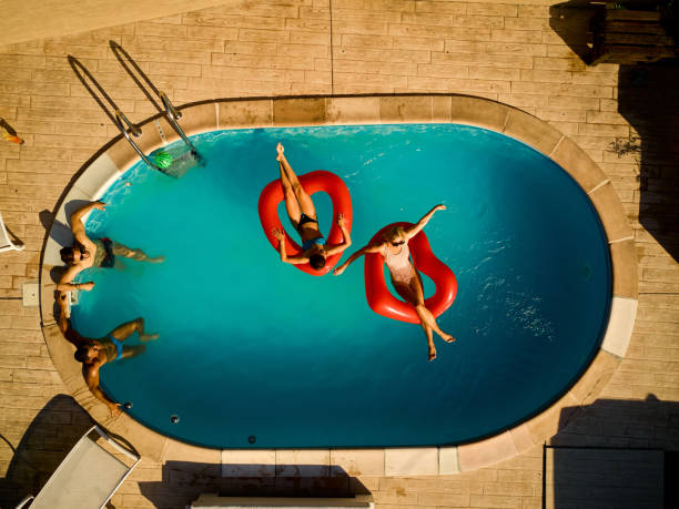 istock Playful friends hanging out at pool party 1394010676