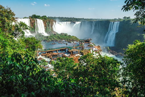 Iguazu Falls, series of cataracts on the Iguaçu River, 14 miles (23 km) above its confluence with the Alto (Upper) Paraná River, at the Argentina-Brazil border. The falls resemble an elongated horseshoe that extends for 1.7 miles (2.7 km)—nearly three times wider than Niagara Falls in North America and significantly greater than the width of Victoria Falls in Africa. Numerous rocky and wooded islands on the edge of the escarpment over which the Iguaçu River plunges divide the falls into some 275 separate waterfalls or cataracts, varying between 200 and 269 feet (60 and 82 metres) in height.