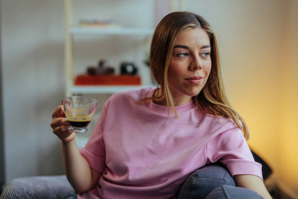 istock Young woman enjoying coffee and relaxing on a sofa 1394012408