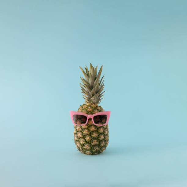 istock Summer background - fresh pineapple with pink sunglasses on blue background. 1394013297