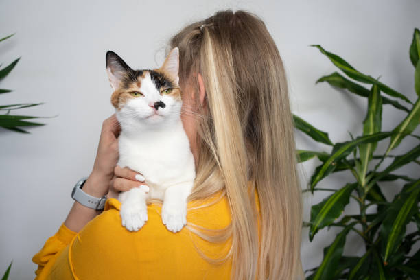 istock young blond woman carrying her cat on shoulder 1394014625