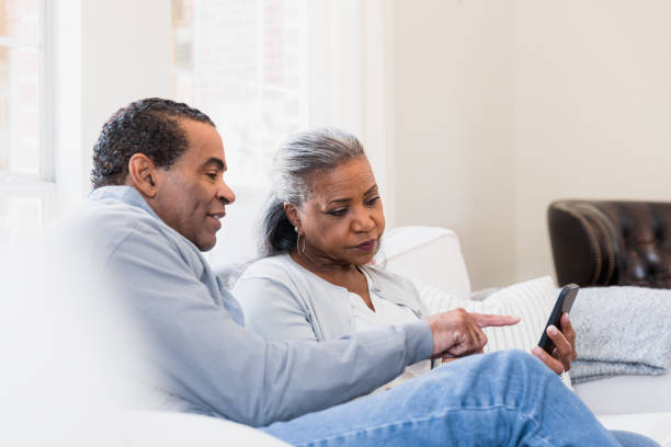 istock Couple sits on the couch reading an article 1394015905