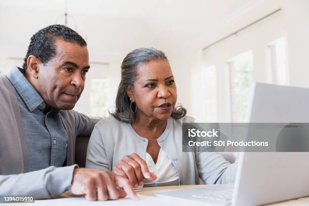 Couple Sit Together At The Computer Stock Photo - Download Image Now - Senior Adult, Decisions, African-American Ethnicity