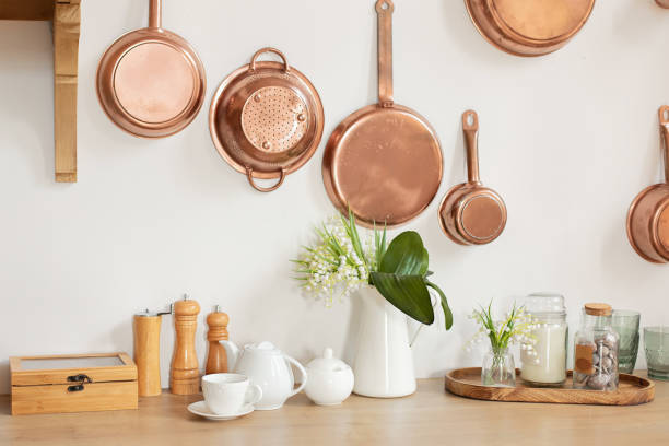 istock Different kind of cookware and ceramic plates on tabletop wooden kitchen. Set of copper saucepans, pans, pots and ladle hanging in kitchen. Hanging kitchen utensil on wall. kitchen interior decor 1394016020