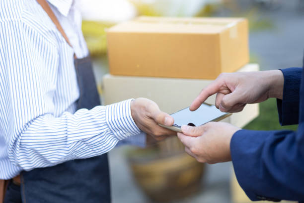 istock Man handwriting on phone to pick up package from delivery man. 1394016642