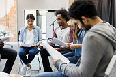 istock Multiracial group sits in circle to read parts 1394017851