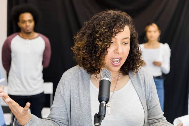 istock Focus on woman reading part in front of microphone 1394017854