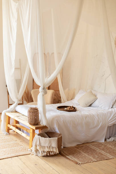 istock interior white bedroom in boho  style with coffe table,straw lamp and comfortable bed with pillows, copy space. bed with flowing white curtains. Cozy scandinavian decoration room. hygge decor at home 1394018196