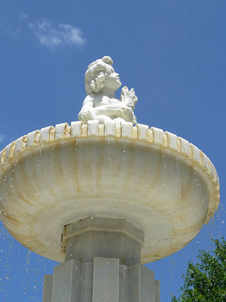 2019 The fountain in Jardin Anglais in Geneva, Switzerland with tourists cooling down around its edge.