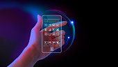 istock Metaverse and blockchain technology concepts. Hand holding a virtual interface screen to an online database smartphone. Futuristic tone purple, neon color. Screen transparent presents the app mobile. Futuristic 1394023631